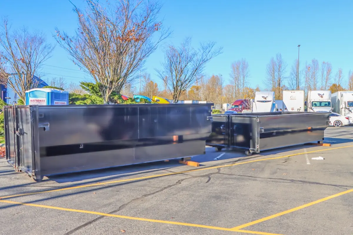 Professional dumpster rental service with roll-off container on residential driveway in Dumont